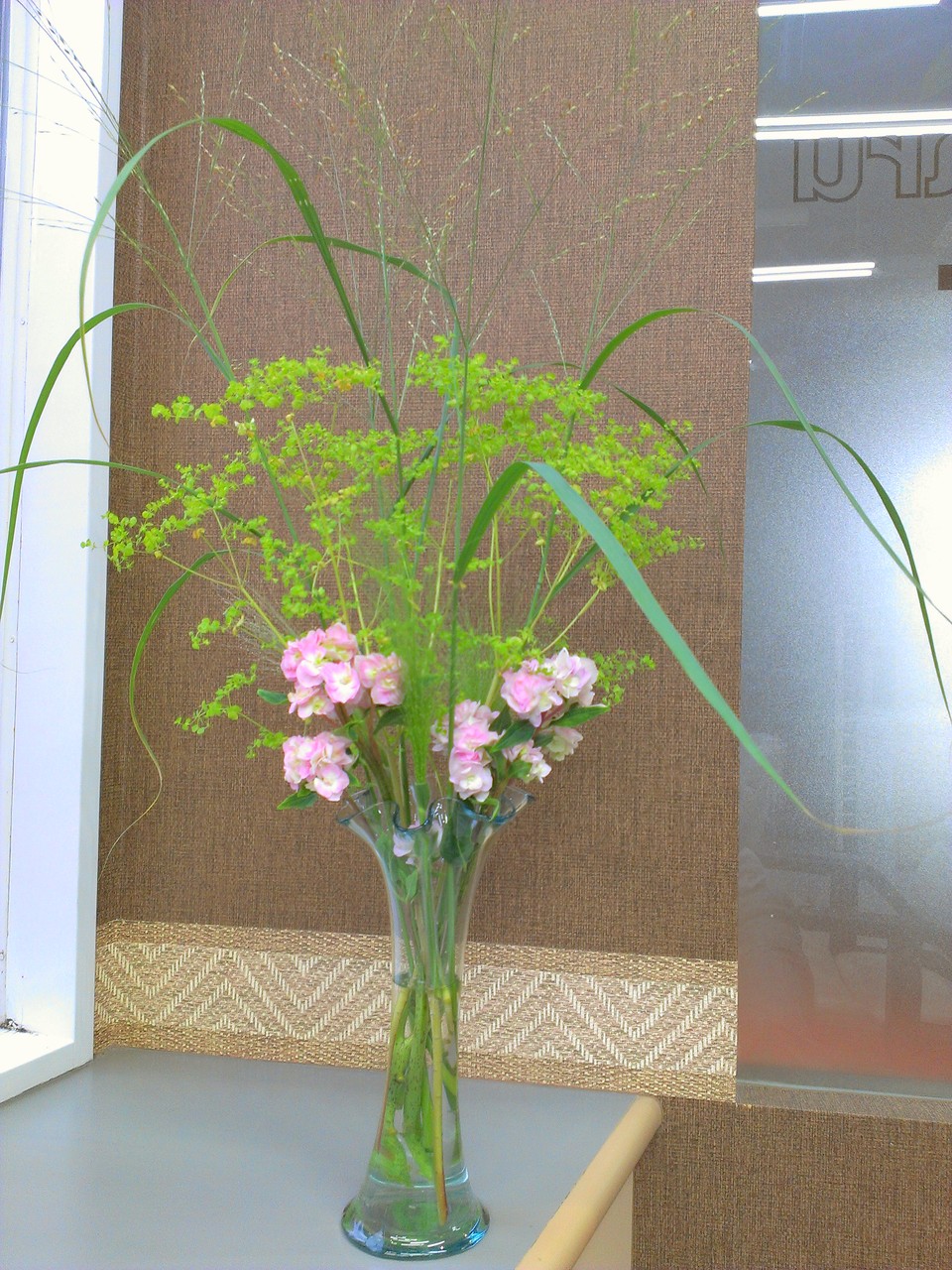 2014.07.23  石化紫陽花、ユーホルビア、パニカム、キリフキ草（スモークグラス）　・幾重にも重なった淡いピンク色の花びらが可愛い石化紫陽花と緑色の小さな花が密集して咲くユーホルビア、スプレーから噴出した水しぶきのような小さなお花がキリフキ草、上に上に枝分かれして伸びるパニカム。涼しげでグリーンが冴える夏をイメージしたアレンジとなります。花言葉：石化紫陽花【辛抱強い愛情】、ユーホルビア【協力を得る】、キリフキ草【率直】