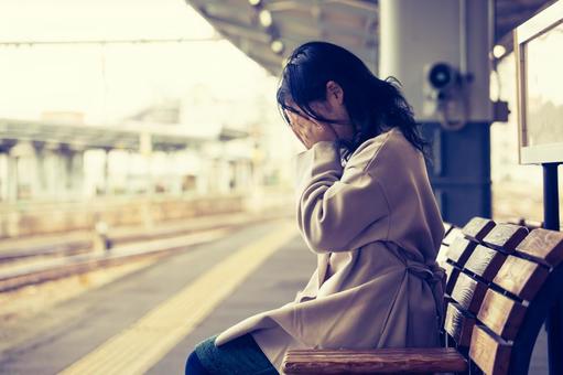 仕事の途中にベンチで泣き、ストレスで悲しみにくれる女性
