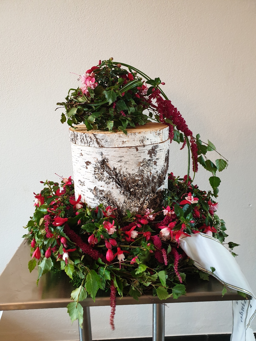 Birkenurne mit Fuchsienkranz in der Friedhofshalle Kempten