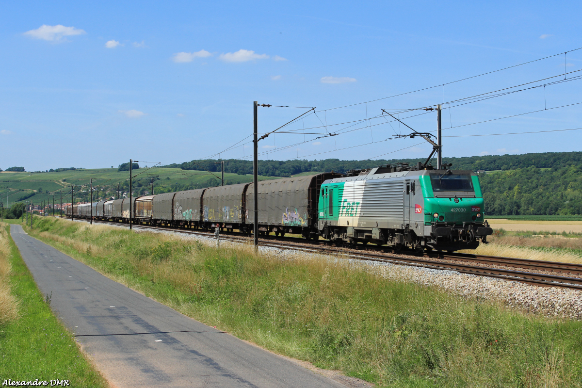 La BB 27030 est vue sur un train Bobigny - Hausbergen dans la campagne marnaise, bien que le train soit encore en Île de France.