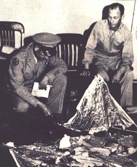 Oficiales de la U.S. Air Force observando restos del globo sonda que fue puesto en lugar del OVNI siniestrado en Roswell.