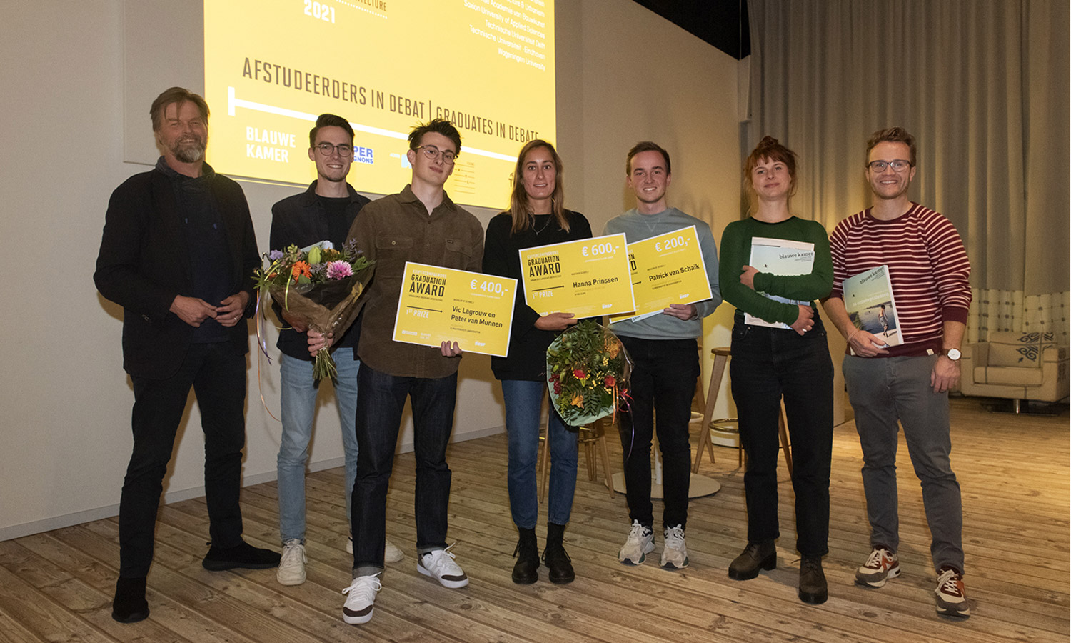 Alle winnaars op de foto, samen met juryvoorzitter Gijs van den Boomen (links) en hoofdredacteur van Blauwe Kamer Mark Hendriks.