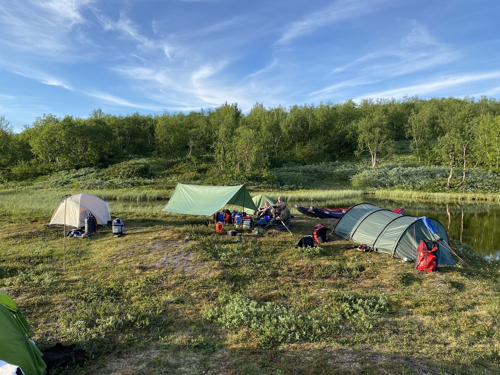 Aufbau von mehreren Zelten auf einer Lichtung in der Wildnis