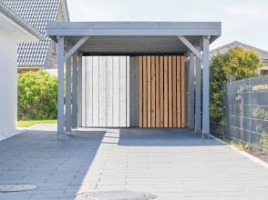 Holzcarport mit integriertem Geräteraum und geschlossenen Wandelementen, fachgerecht montiert in Dresden als funktionaler Carport-Anbau.