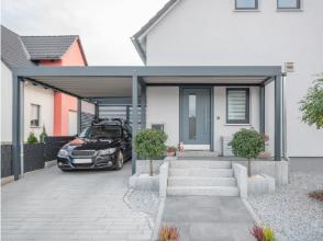 Moderner Metallcarport mit Flachdach, klarer Linienführung und gepflasterter Einfahrt, fachgerecht montiert in Dresden.