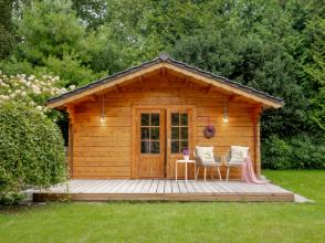 Blockbohlen-Gartenhaus aus Holz mit Satteldach und Terrasse, hochwertig umgesetzt in Dresden als langlebiges Gartenhaus im Grünen.