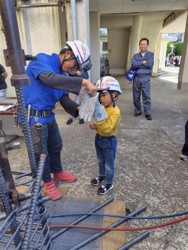 職人から皮手袋を受け取るこども