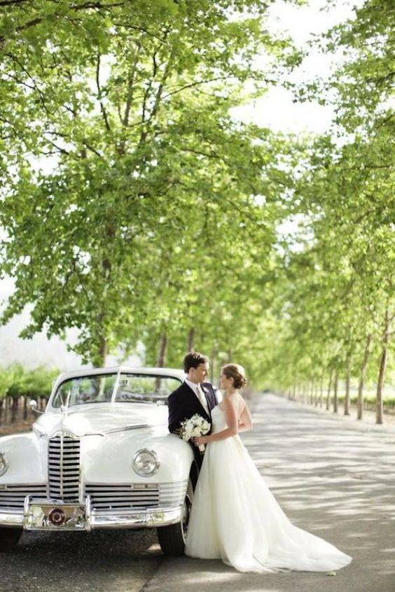 Deux amoureux qui prennent la pose à côté de leur véhicule