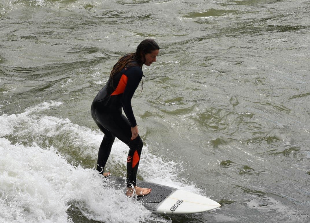 Nun mit aufgerichtetem Oberkörper und leicht gebeugten Knien, surfen