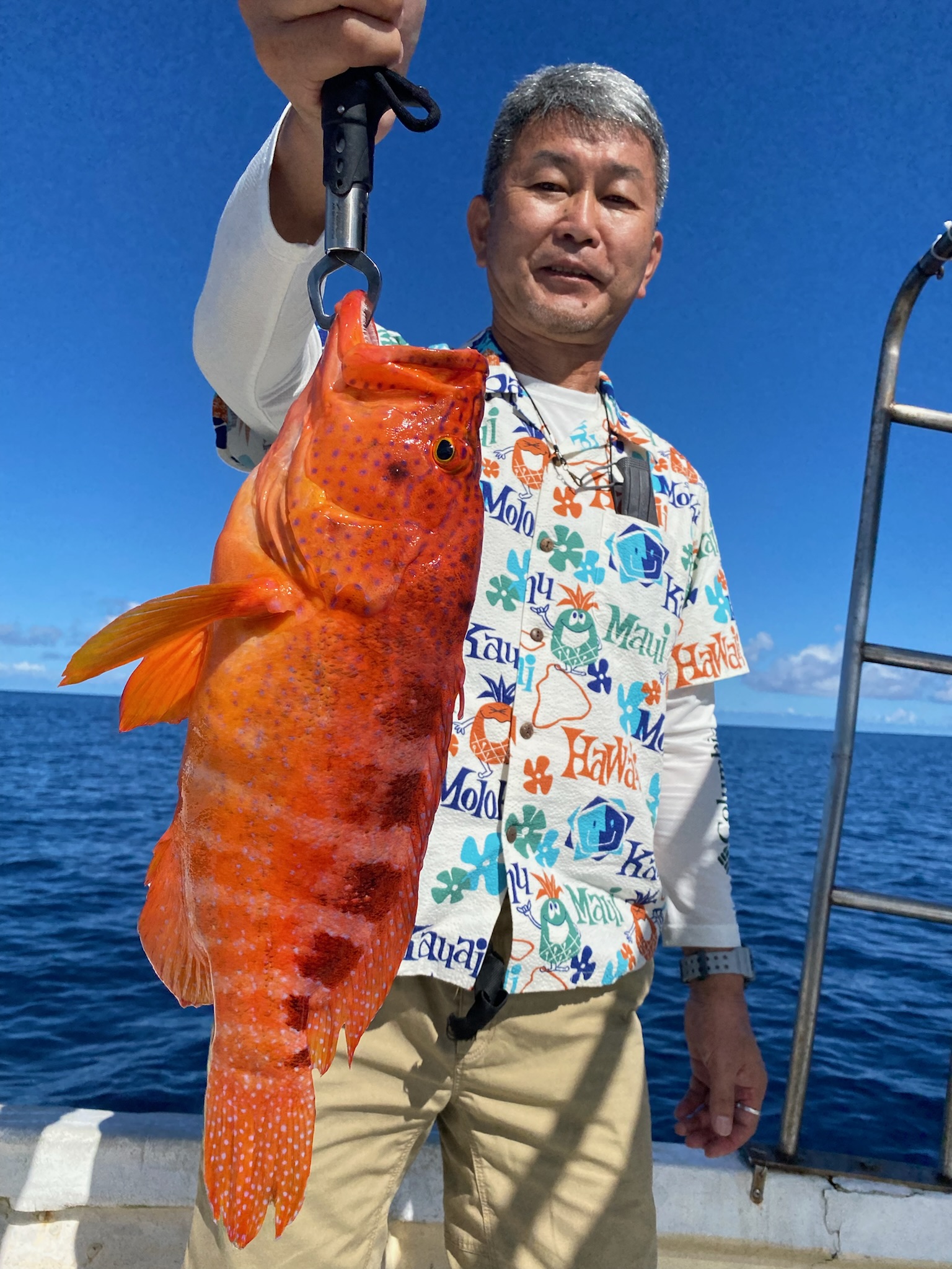赤い魚を釣る男性