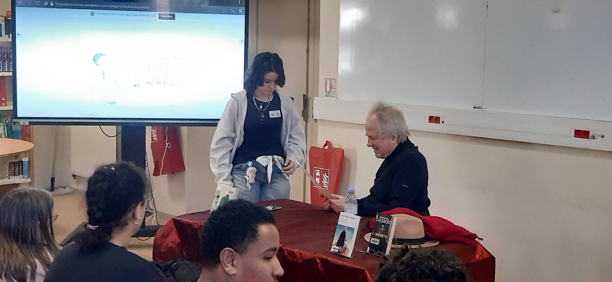 Penelope présente son dessin de presse à F.-O. Giesbert