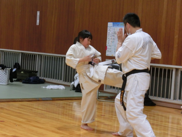 小学生の女子がキックミットの練習をしているところ