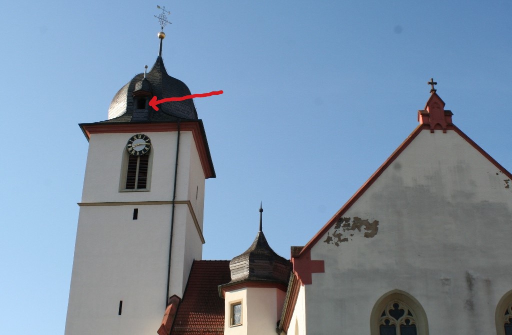 Hoch über den Glocken des Kirchturms in Unterschüpf ist ein Turmfalkenkasten eingebaut.