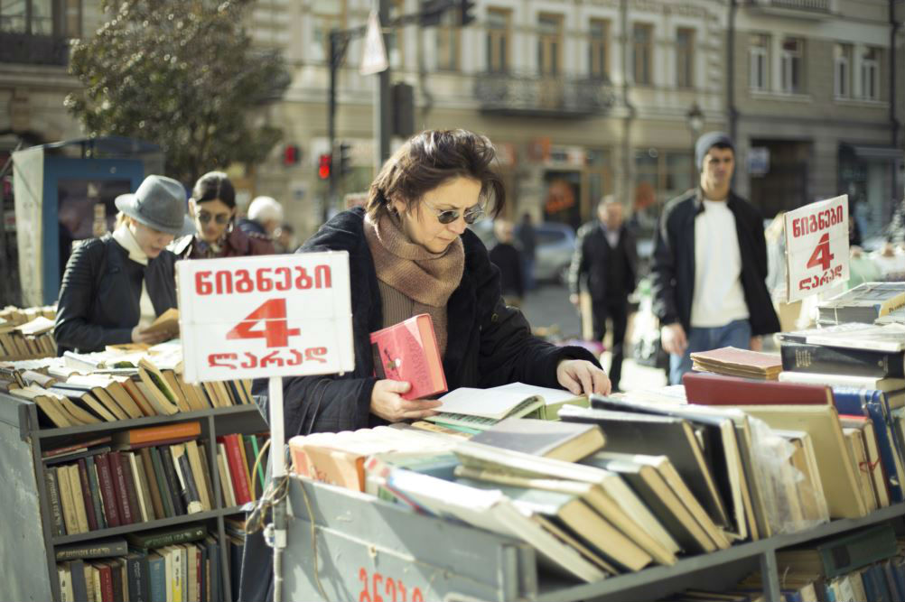 Девушка рассматривает подержанные книги в центре Тбилиси. Фото: Indigo Fleur