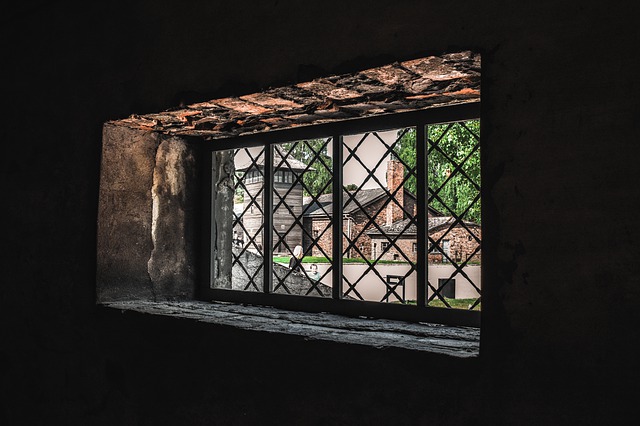 Vue de la cour d'Auschwitz à travers les barreaux d'une fenêtre. 