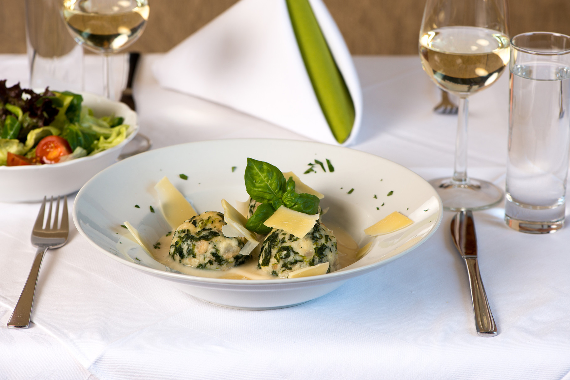 Spinatknödel auf Käsesauce