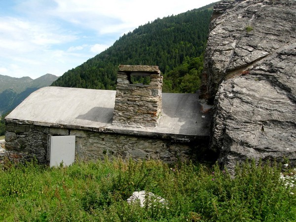 Grange protégée par un immense rocher. L'habitat traditionnel s'est adapté intelligemment au risque d'avalanche. © C-PRIM 2010