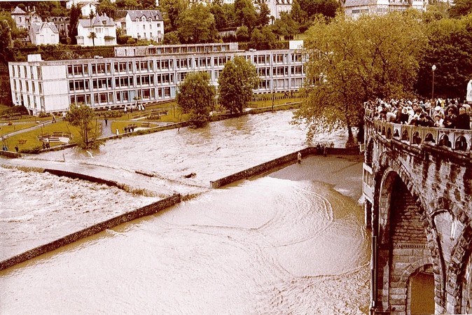 1er Juin 1979. La passerelle de la basilique est submergée par les flots boueux. Un embâcle (accumulation de déchets flottants) s’est formé sur le parapet. Les troncs d’arbres emportés par le courant ont endommagé ce dernier.  © F. DUPLAN