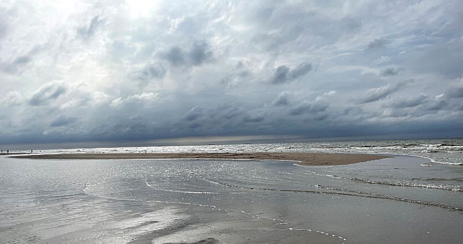 Weiter Strand mit Wolkenhimmel symbolisiert Akzeptanz als Weg aus dem Gedankenkarussell