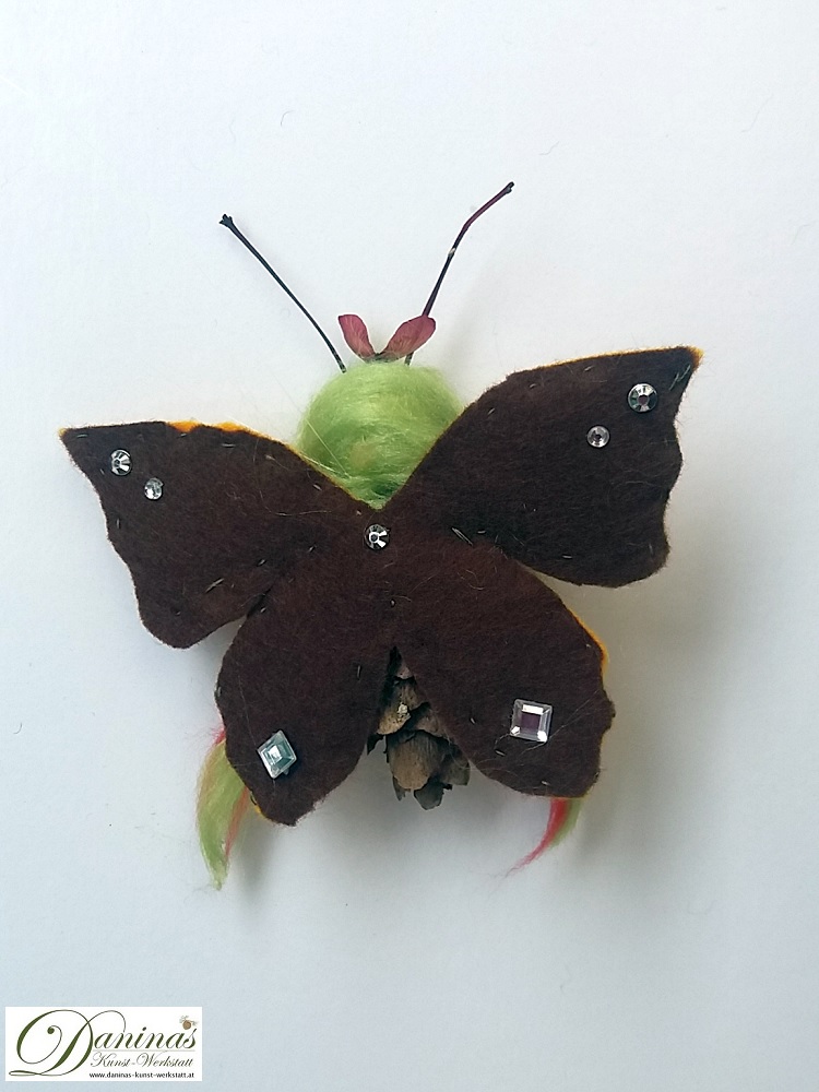 Butterfly-Elfe, Rückseite. Handgefertigte Elfenfigur aus Douglasienzapfen, Haaren aus Wolle, Ahornsamen Krone und Filz Schmetterlingsflügeln