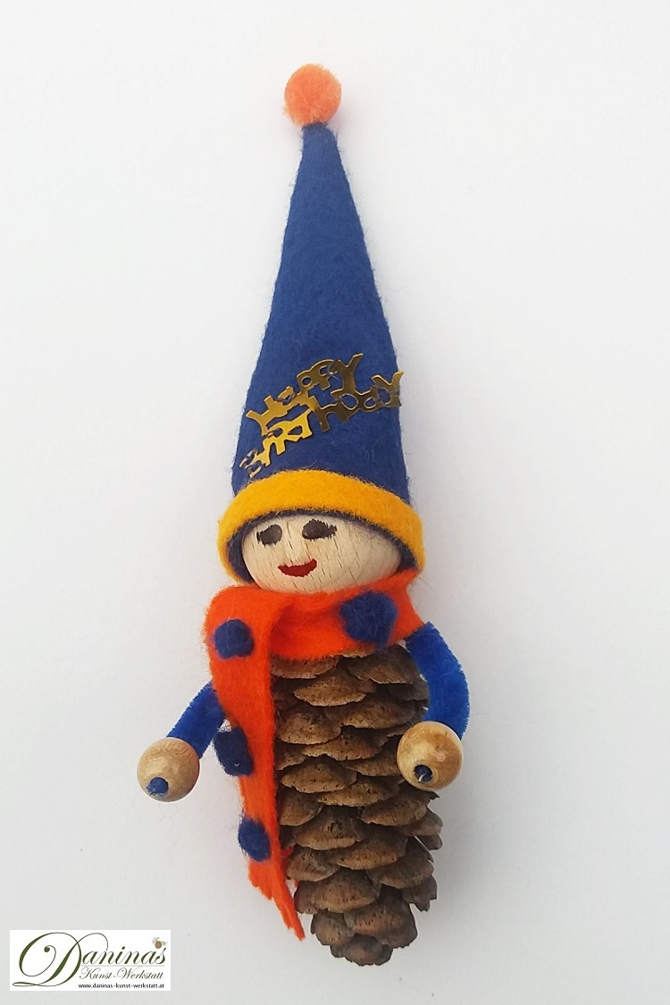 Geburtstagswichtel Benno. Handgefertigte Wichtelfigur aus Fichtenzapfen, mit orangem Schal und blauer Zipfelmütze aus Filz mit blau-orangen Bommeln