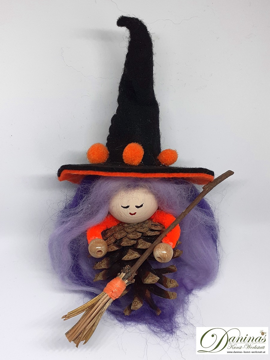 Hexe Holunda. Handgefertigte Märchenfigur aus Kiefernzapfen, mit violett-lila langen Haaren aus Wolle und schwarz-orangem Hexenhut aus Filz, Hexenbesen aus Kiefernnadeln
