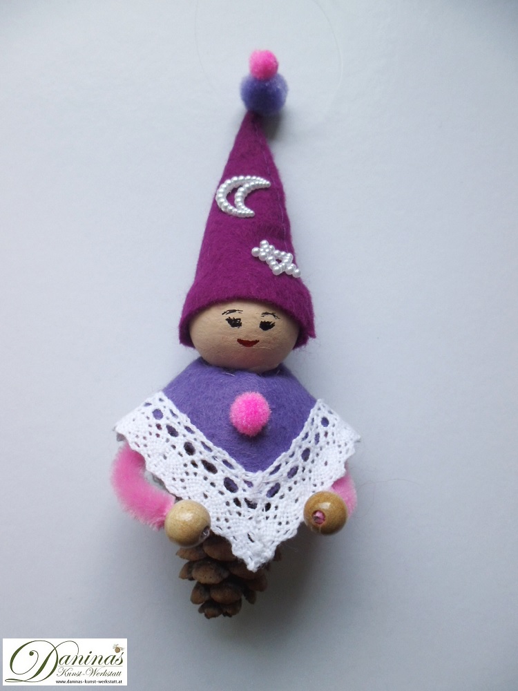 Zauberfee Figur Fräulein Abendstern aus Lärchenzapfen, mit violetter Zipfelmütze und lila Mantel aus Filz mit Spitzenbordüre und Zierperlendeko