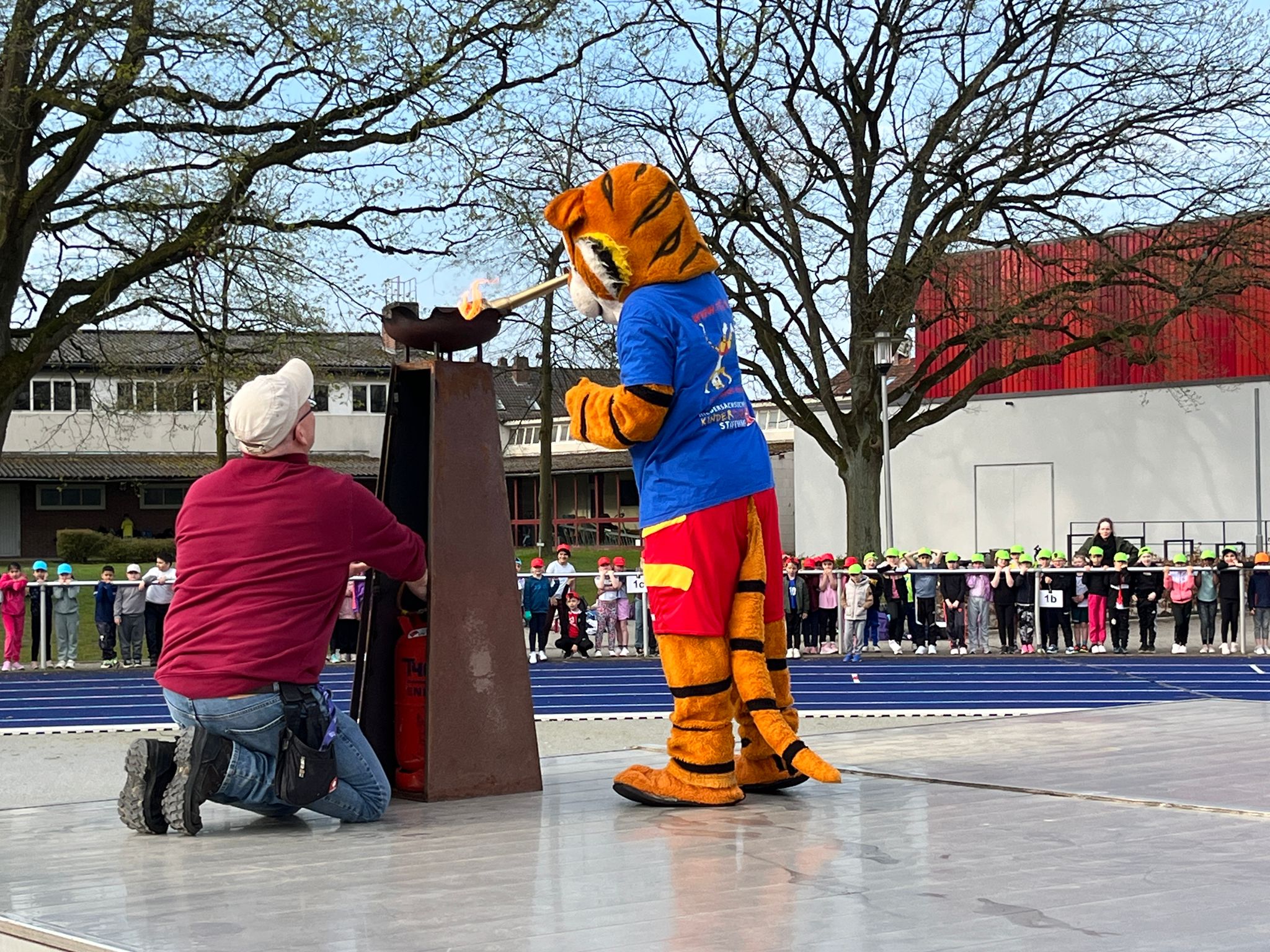 Der Turntiger entzündet die olympische Flamme.