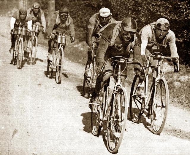 Bikepacking Italien - von Livorno nach Rimini: Historische Aufnahme eines Radrennens mit mehreren Rennfahrern auf Schotterstraße, schwarz-weiß Fotografie.