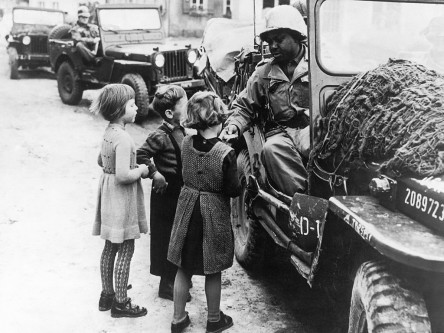 Ein amerikanischer Soldat schenkt Kindern Schokolade