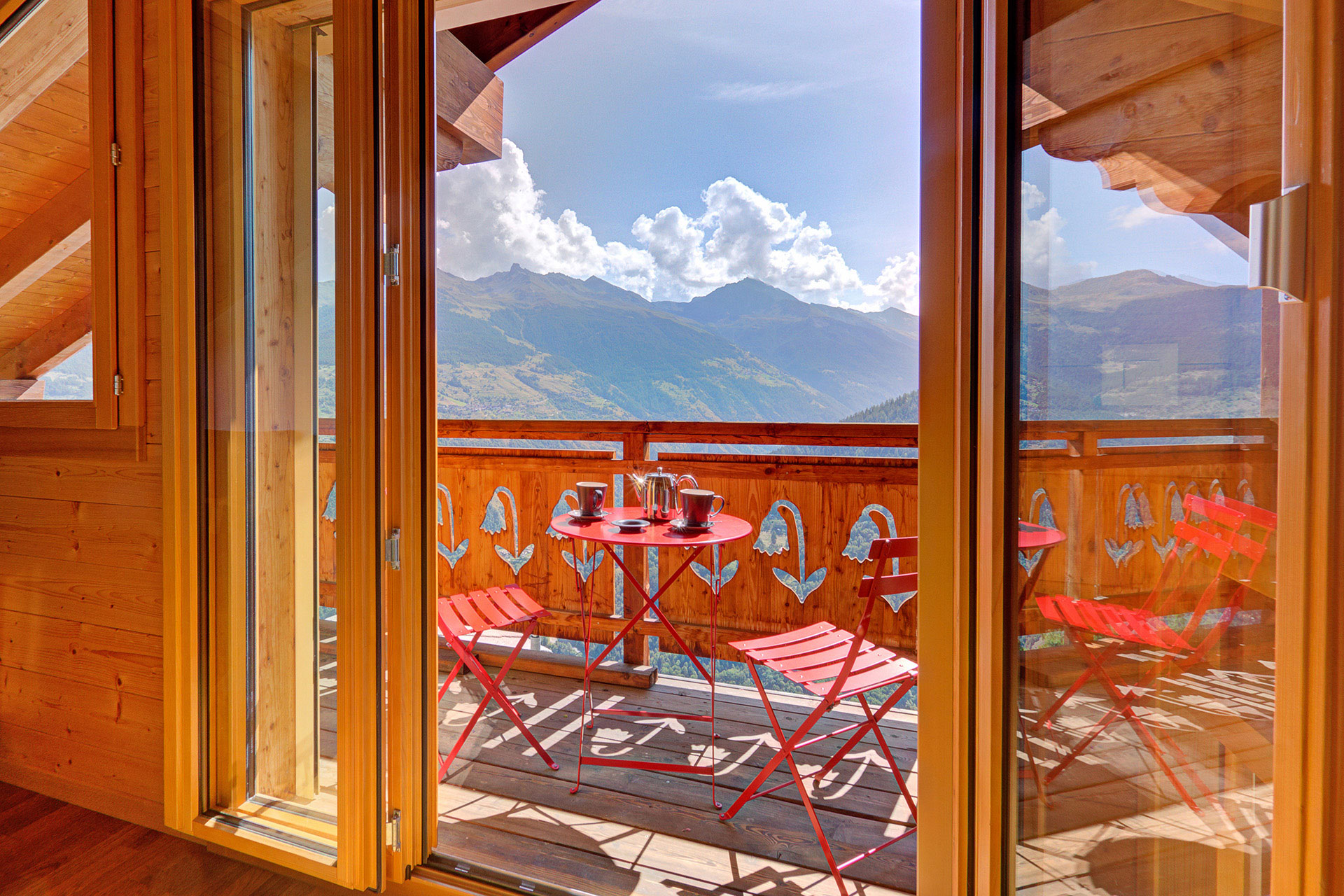 ferienhaus foto balkon mit roter sitzgarnitur und sommerbergpanorama