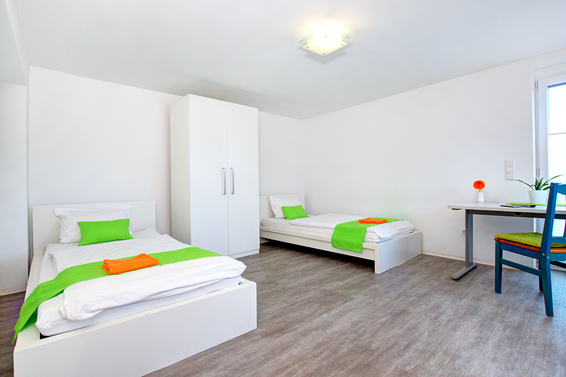 monteurzimmer fotografieren zwei einzelbetten mit grünen bettläufern und schrank