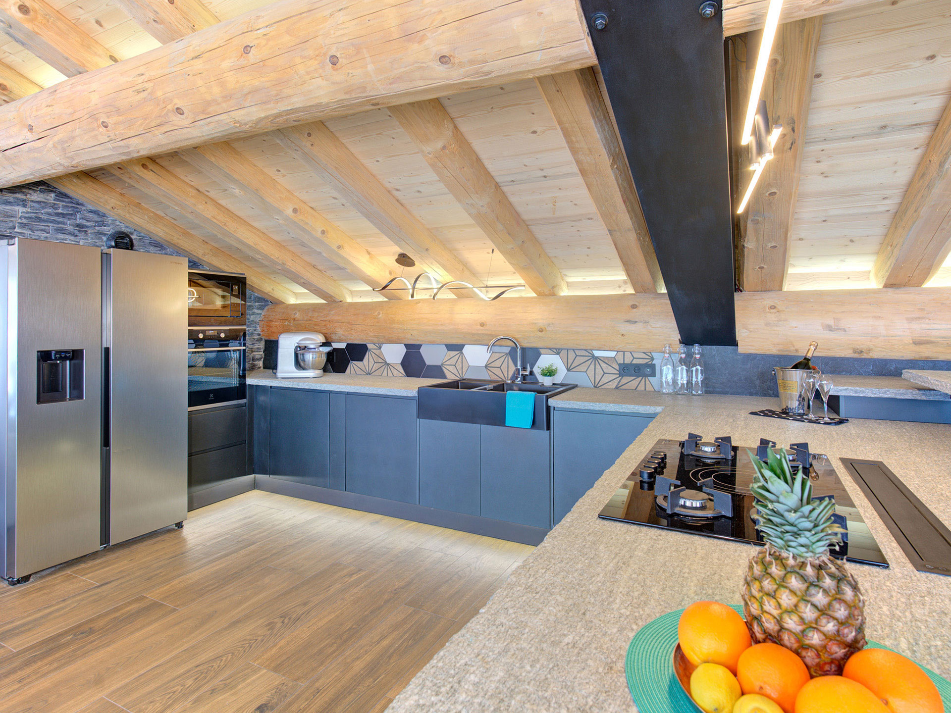 Offene Küche im Luxus-Chalet mit Naturstein und Holz