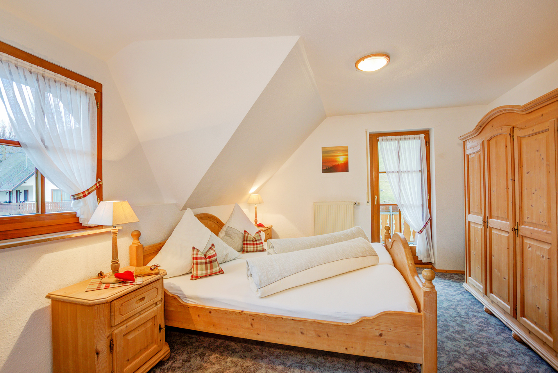grosses doppelbett aus holz mit nachttischlampe in ferienwohnung