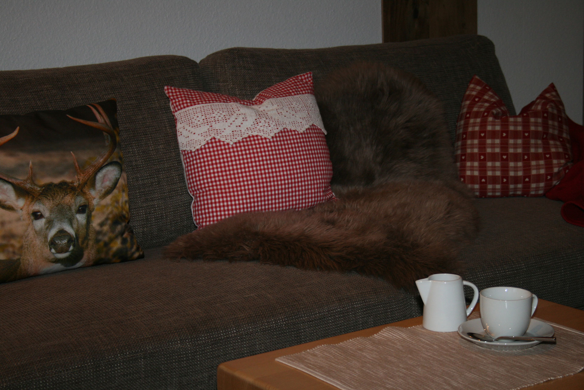 foto verbessern sofa mit rotweiskariertem kissen voher dunkel