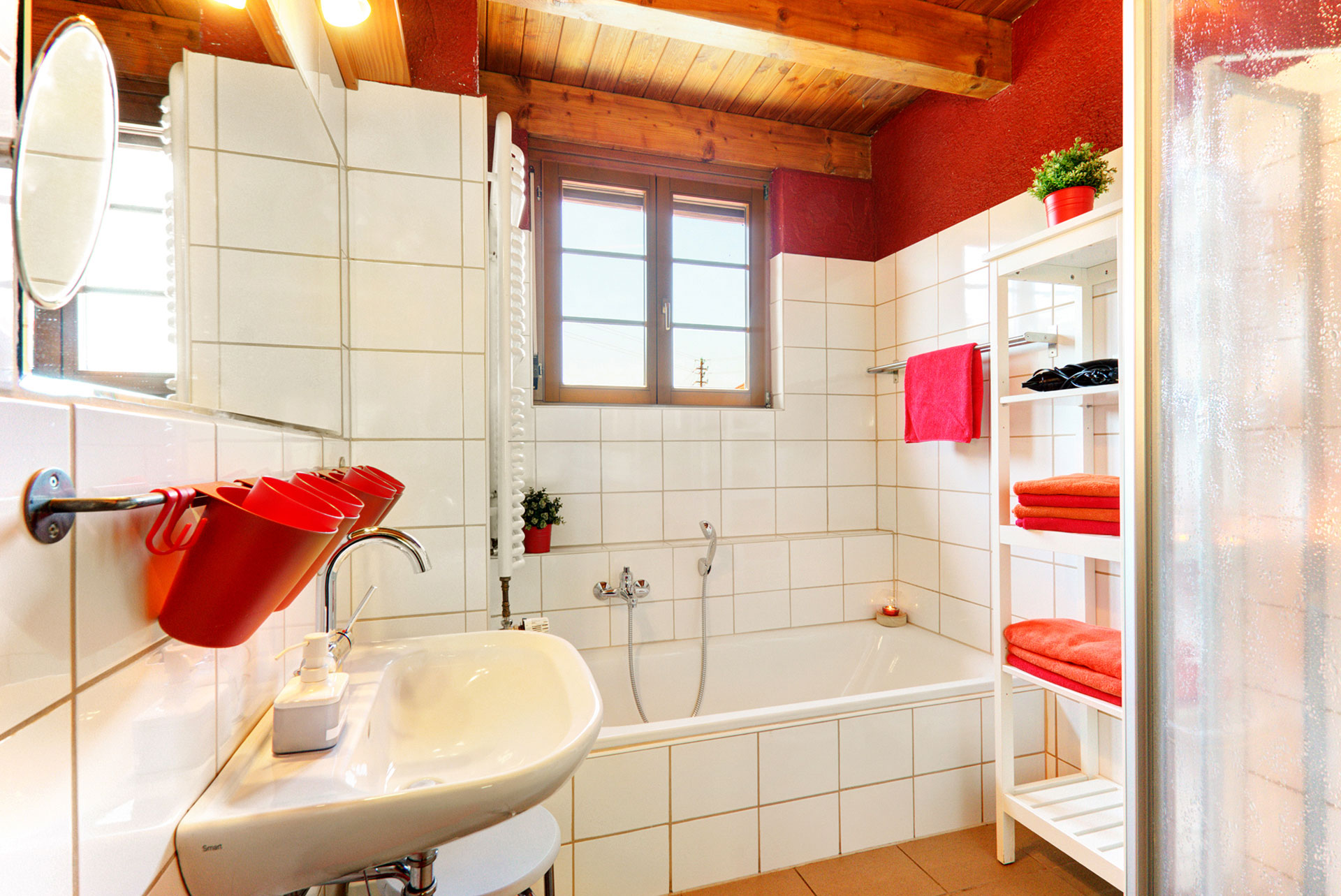 badezimmer mit roten handtüchern im ferienhaus