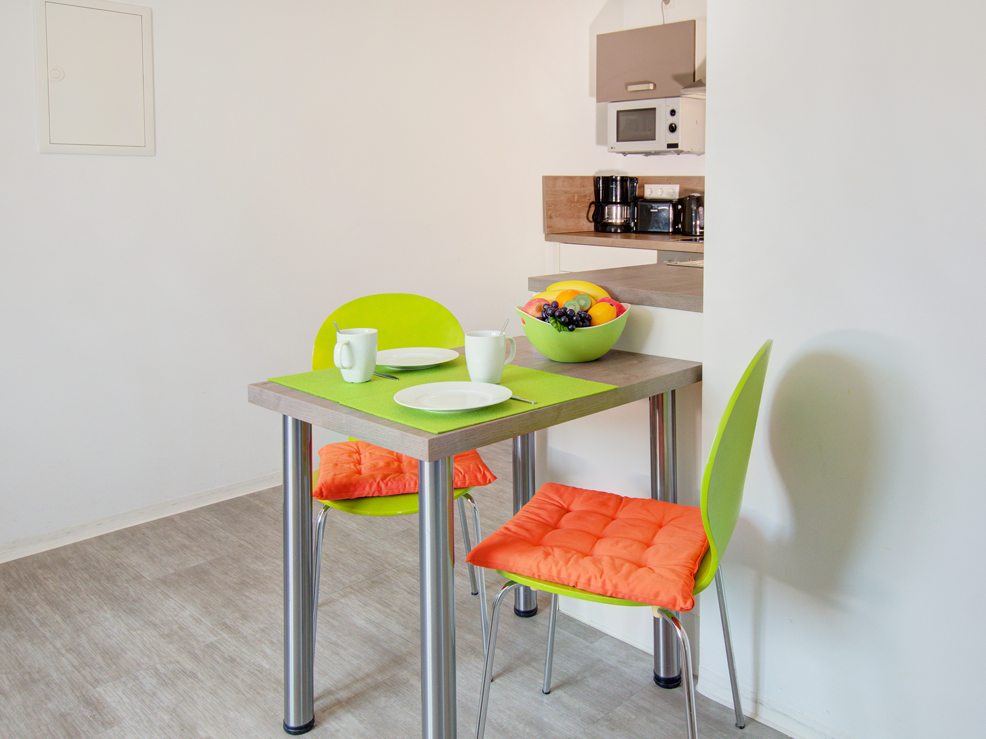monteurzimmer fotografieren zweier esstischgarnitur in grün und orange