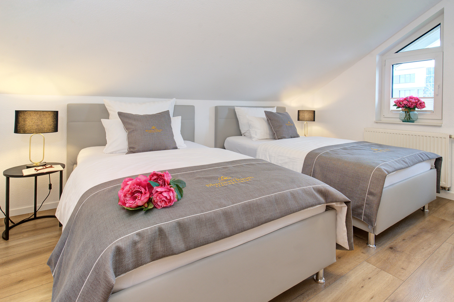 Schlafzimmer der Ferienwohnung mit drei Betten Bettläufer mit pfingstrose Nachttisch gemütliche Beleuchtung im Dachgeschoss