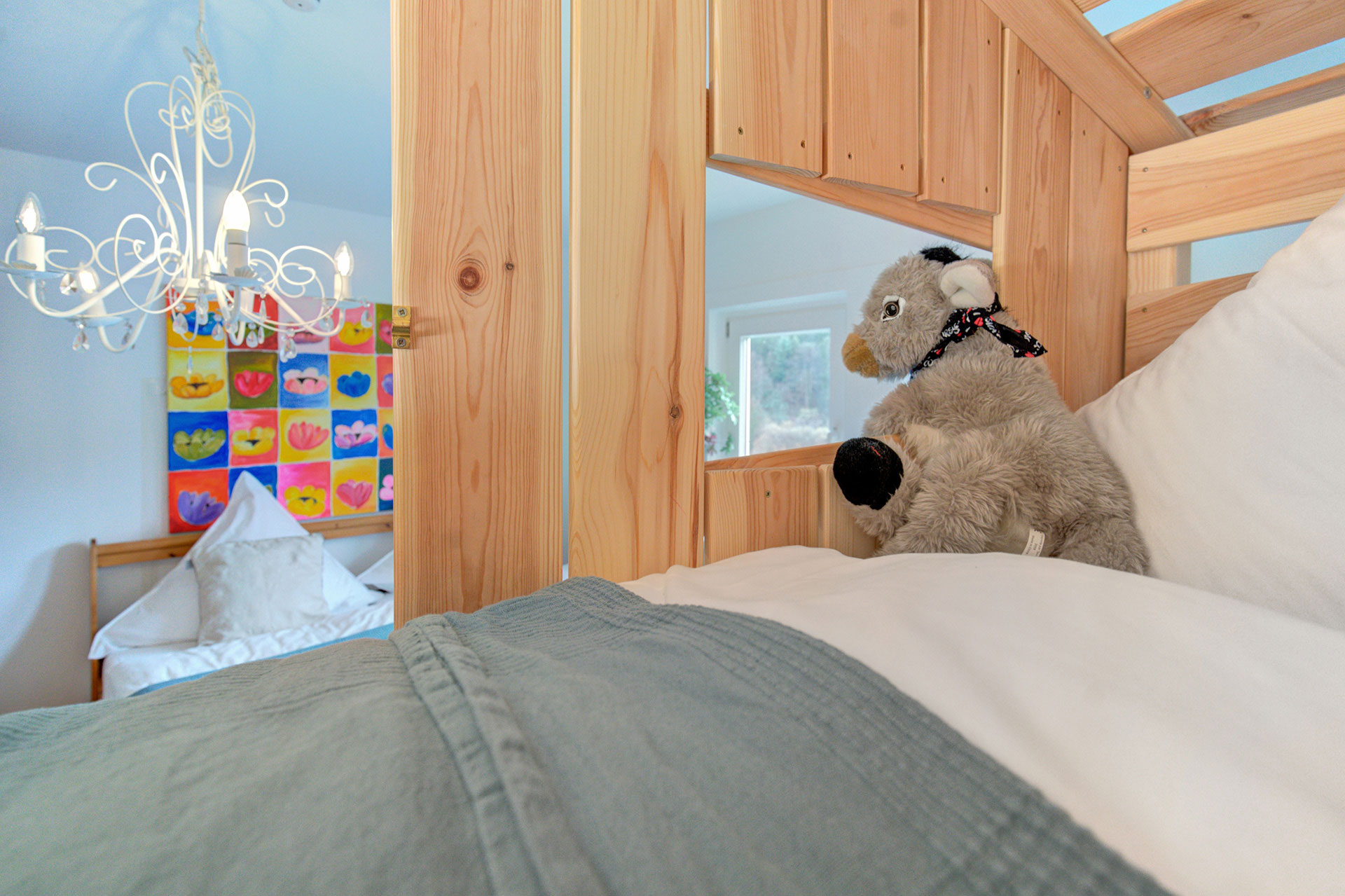 blick vom hochbett mit esel aufs doppelbett und kronleuchter