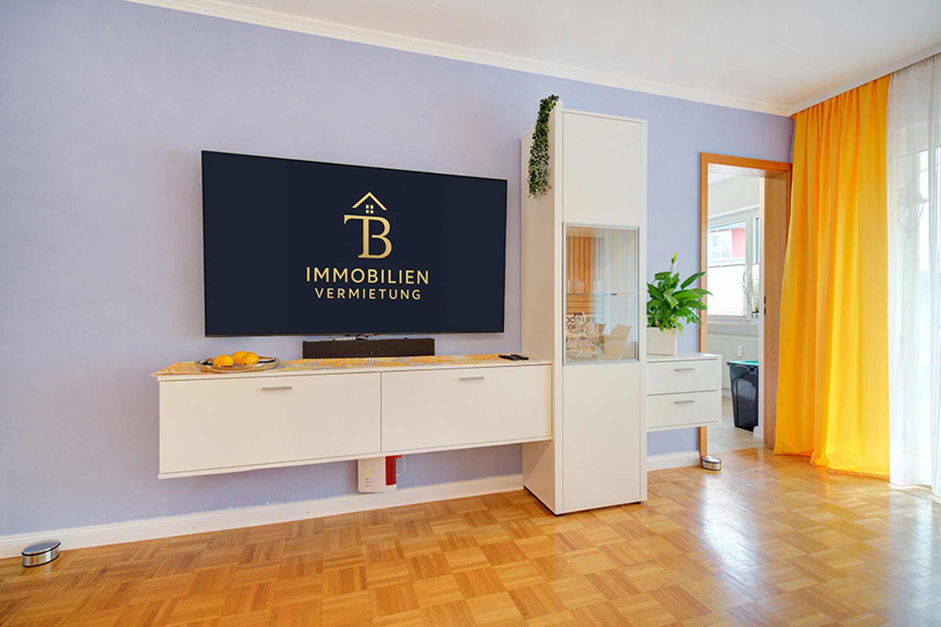 Bild eines modernen Fernsehbereichs in einer Ferienwohnung; auf dem Monitor ist das Eigentümer-Logo zu sehen