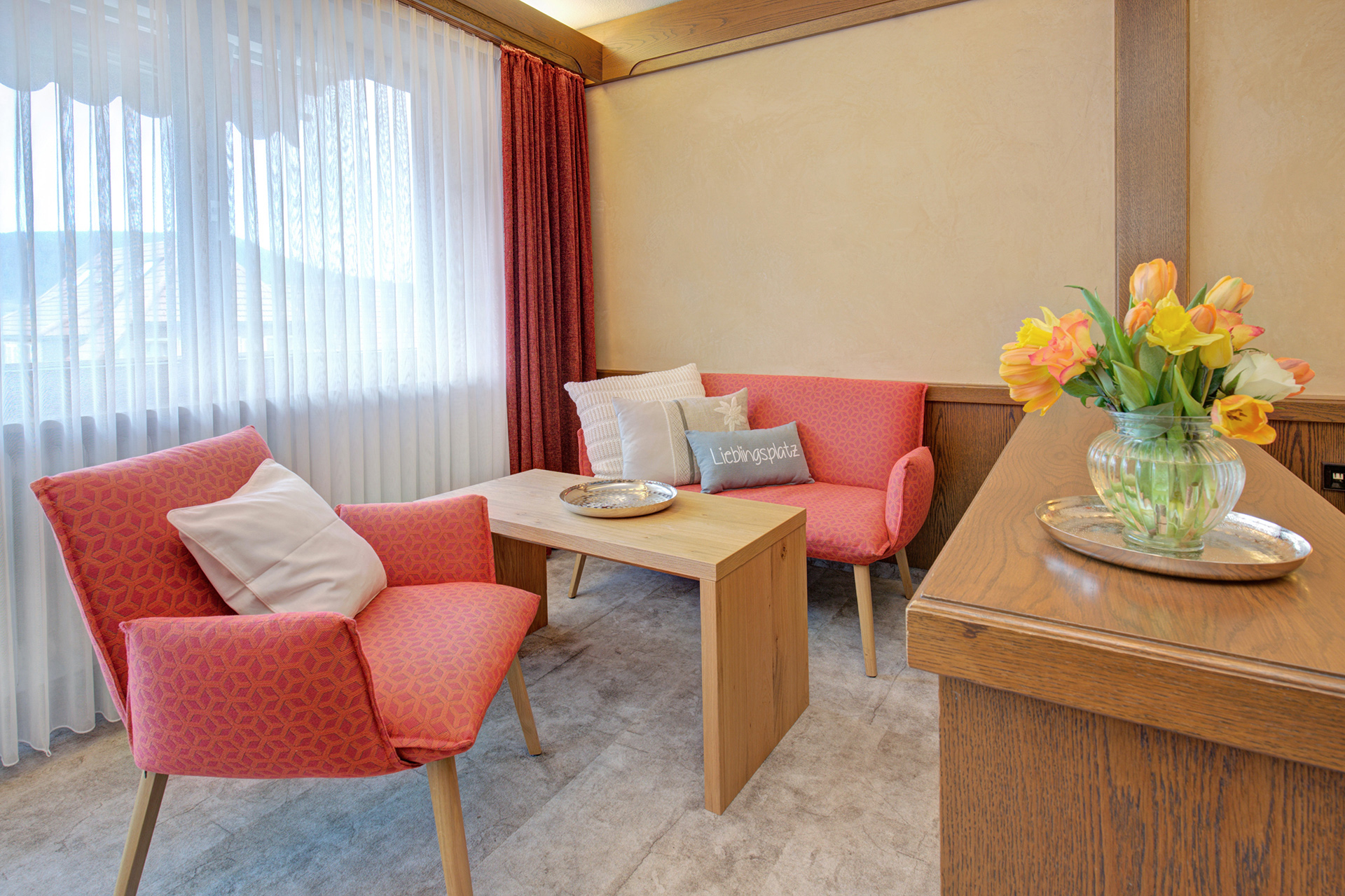 hotelfoto rote sitzecke mit tulpen im Vordergrund