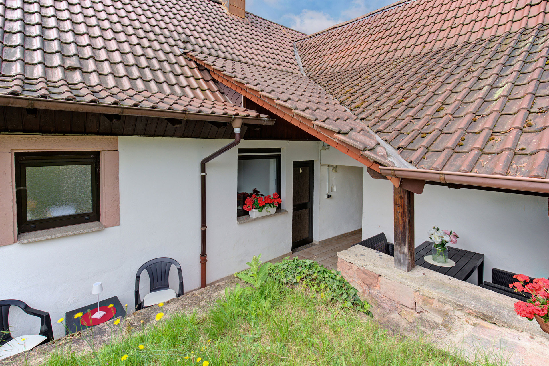 Ferienhaus von hinten mit Sitzgelegenheiten