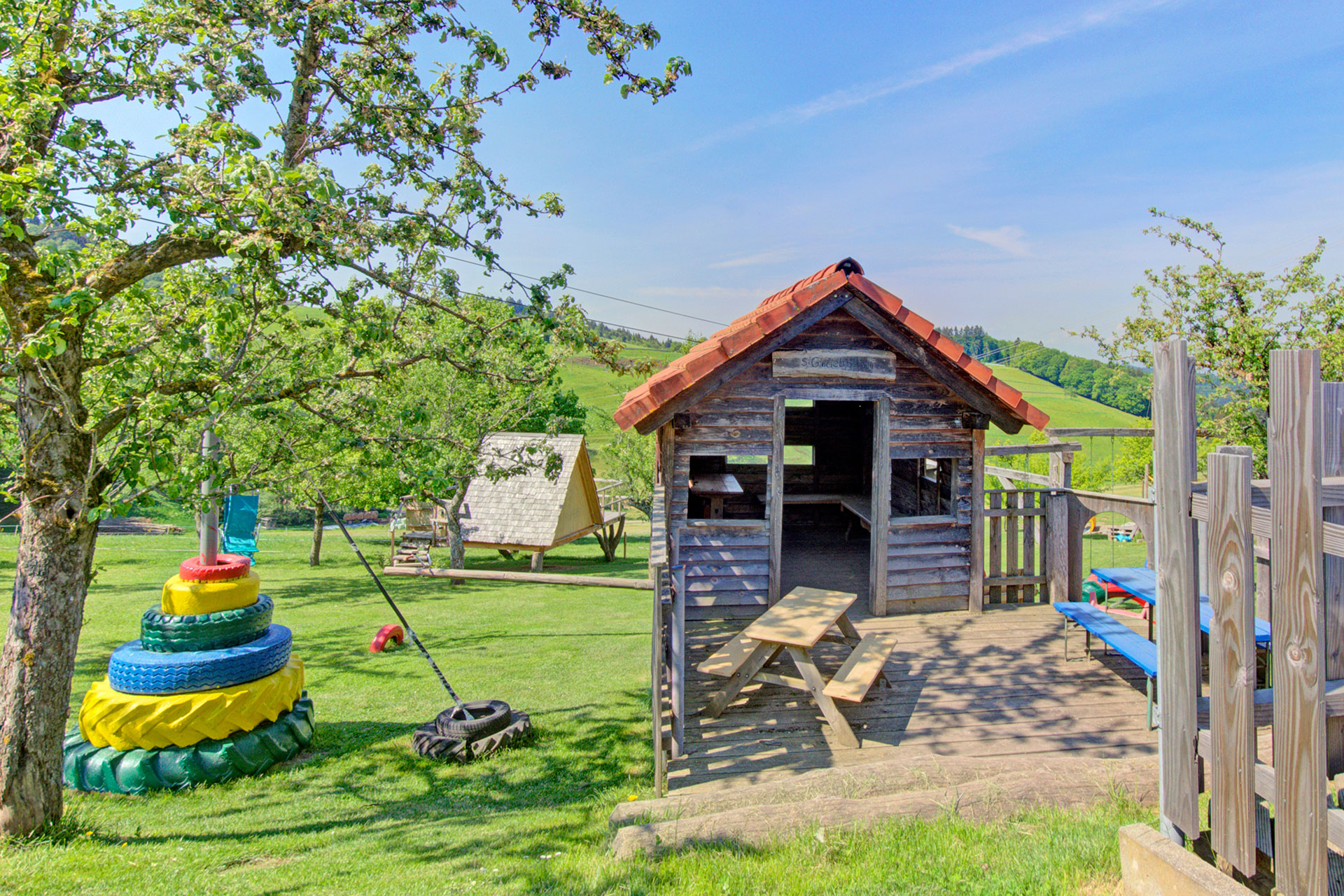 spielhütte mit reifenturm und streuobstbäumen beim ferienhof