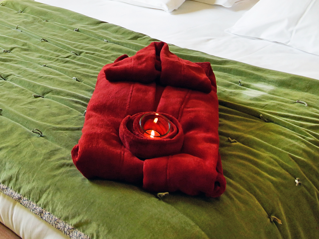 fotografin dekoriert roten bademantel mit teelicht