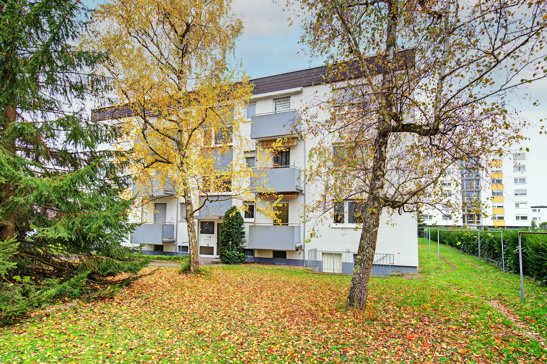 Aussenansicht vom Gebäude Garten und Wohnung im Herbst 