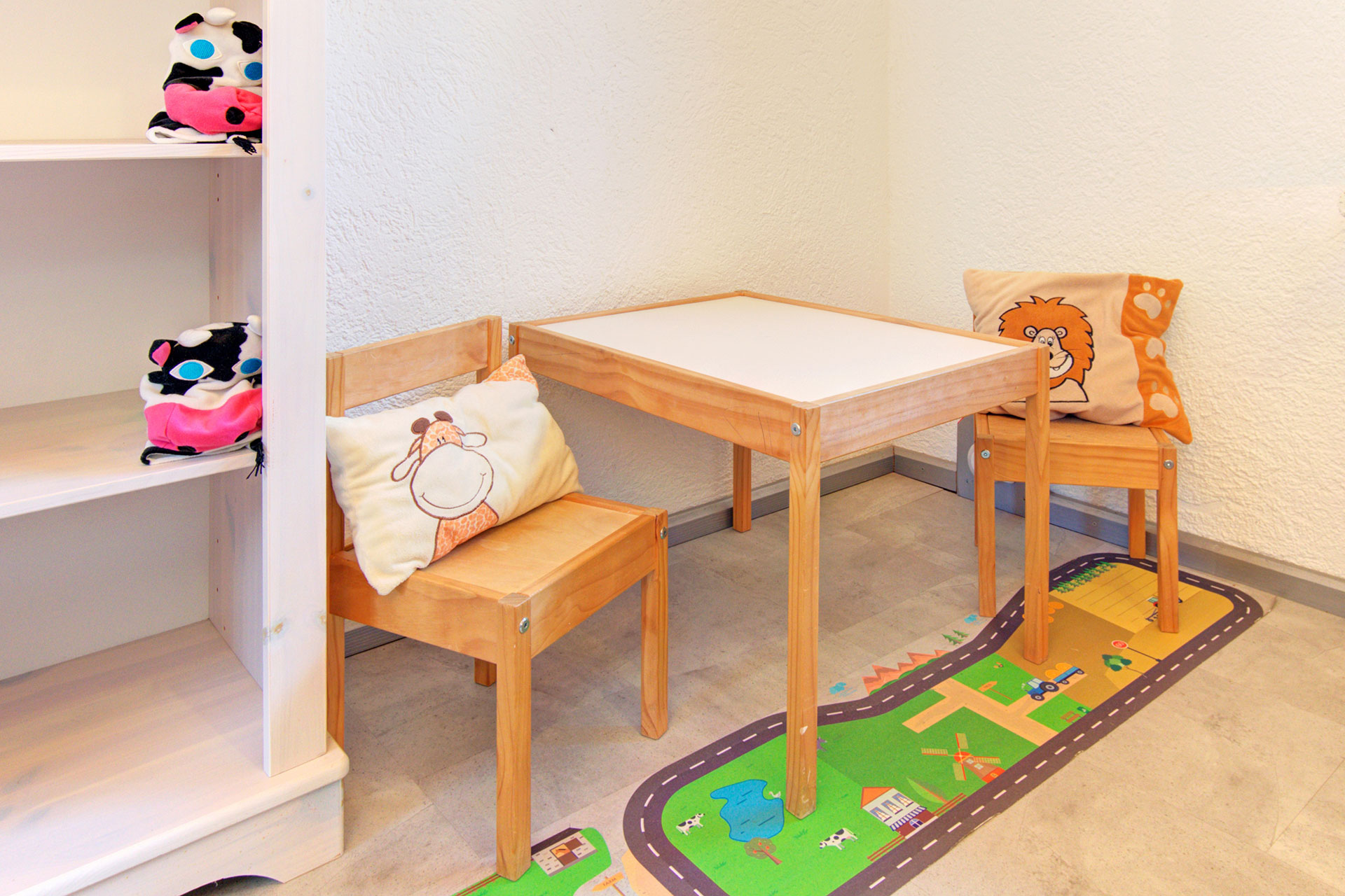 kindertisch mit zwei stühlen und spielteppich in ferienhaus
