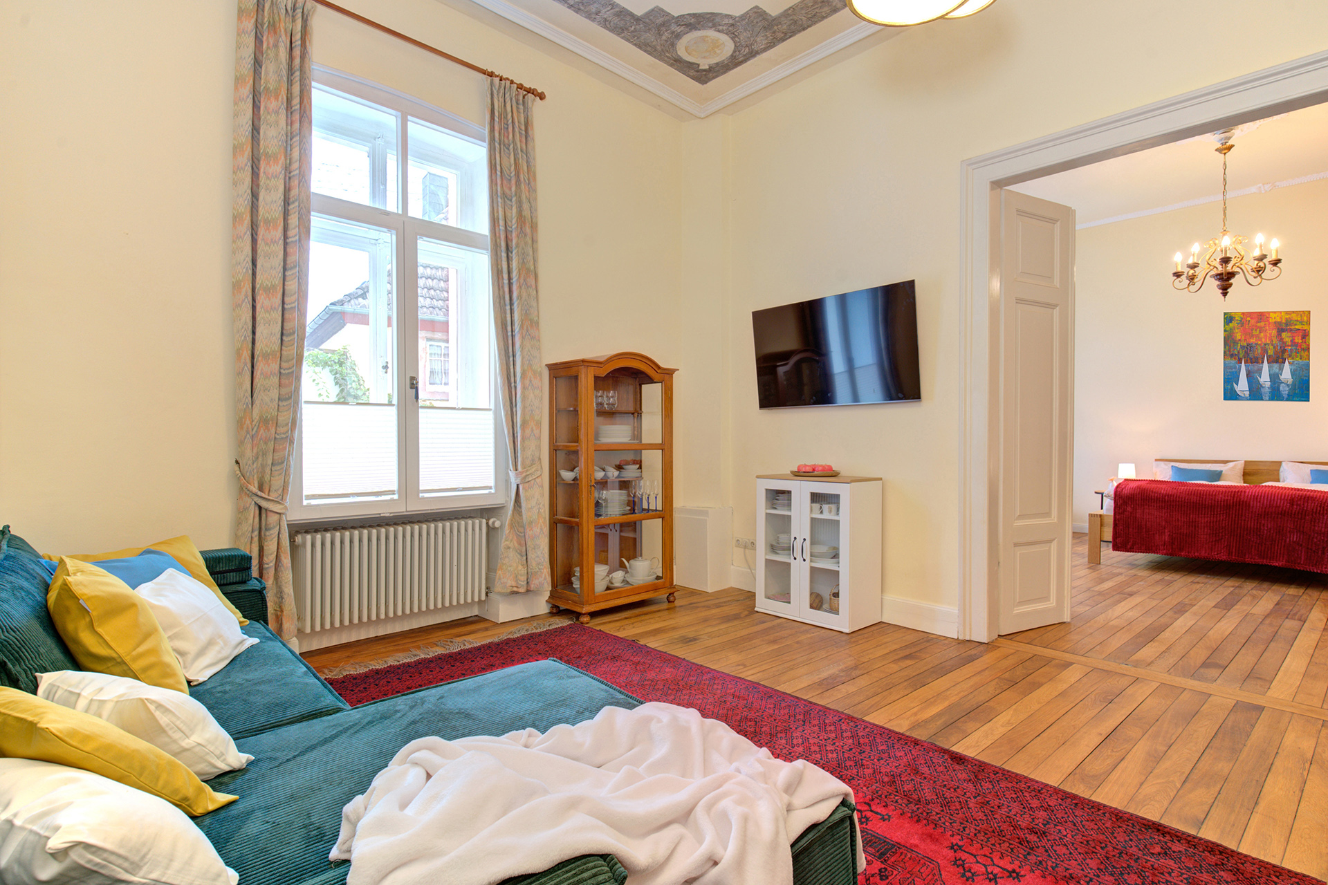 wohnraum mit sofa und tv sowie blick aufs fenster