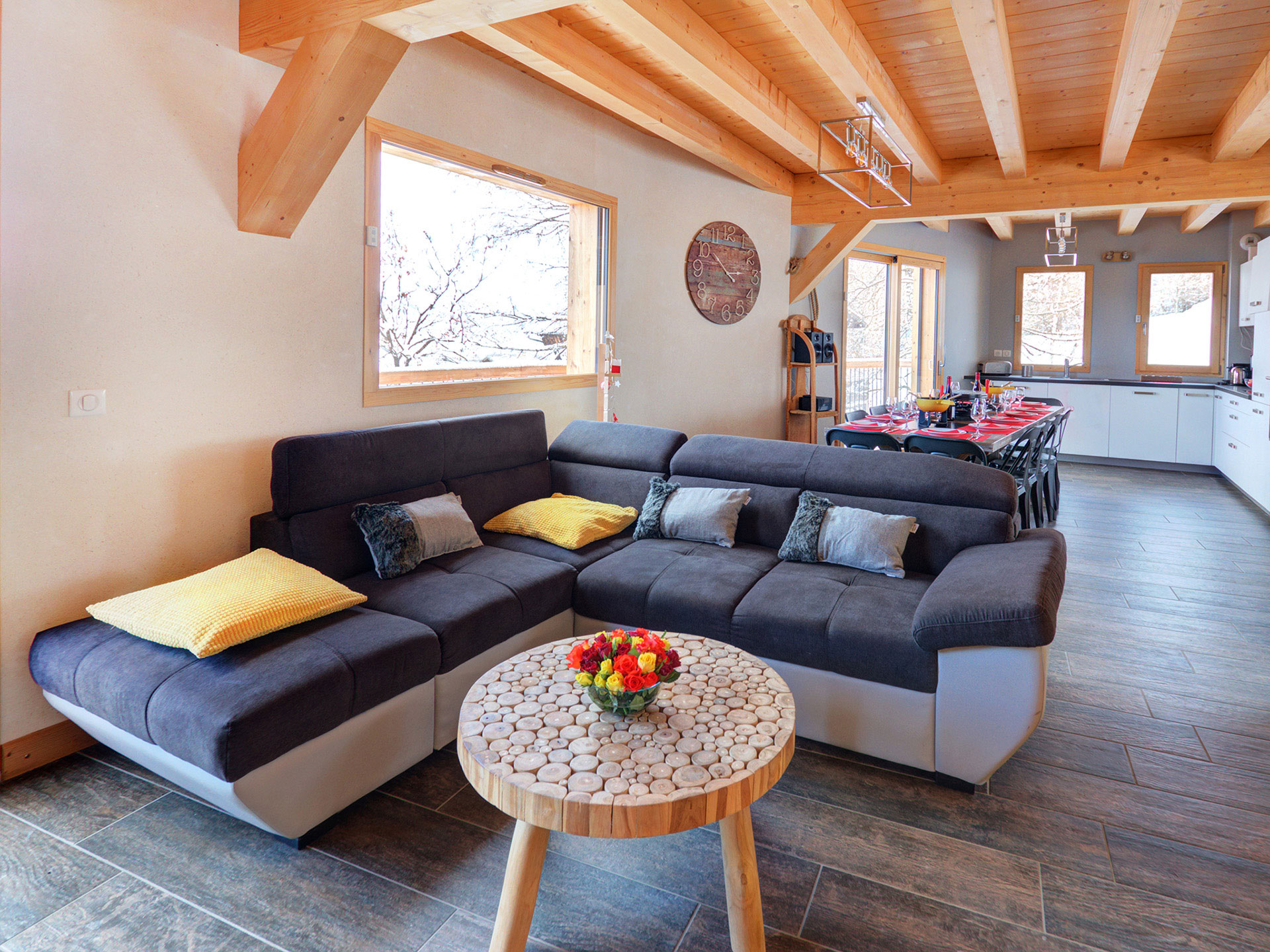 Helles Wohnzimmer eines Ferienhauses mit sofa, tisch und großen Fenstern, freundliche Beleuchtung mit Bildbearbeitung nachher