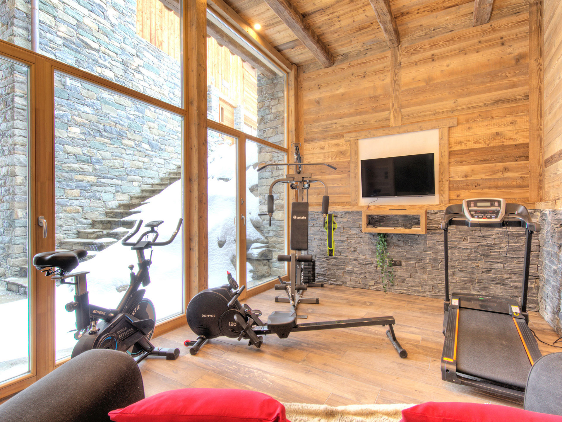 Immobilienfoto: Einladender Fitnessraum mit verschiedenen Geräten und TV-Gerät
