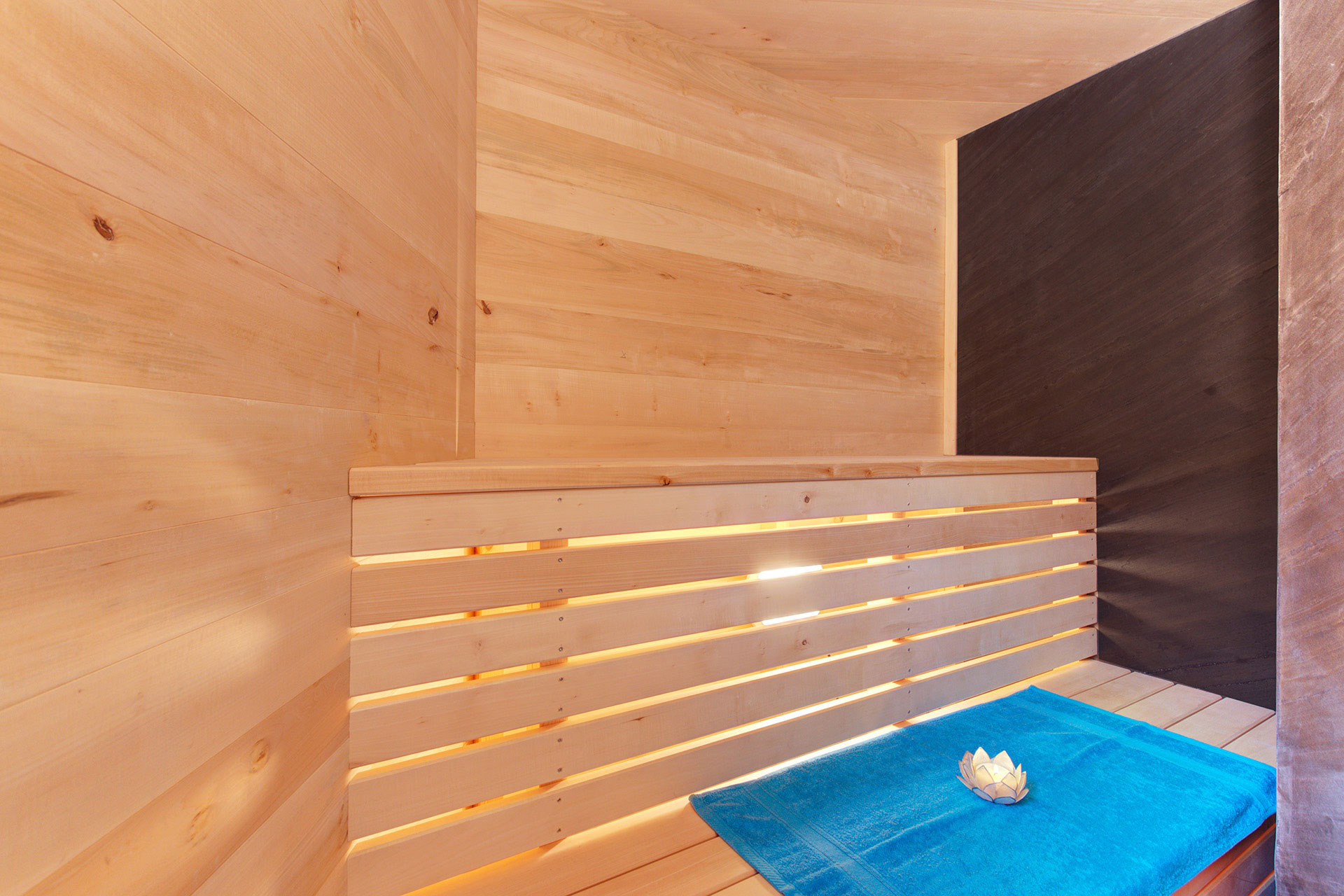 ferienhaus foto kleine sauna mit tuerkisfarbenen handtuch und teelicht